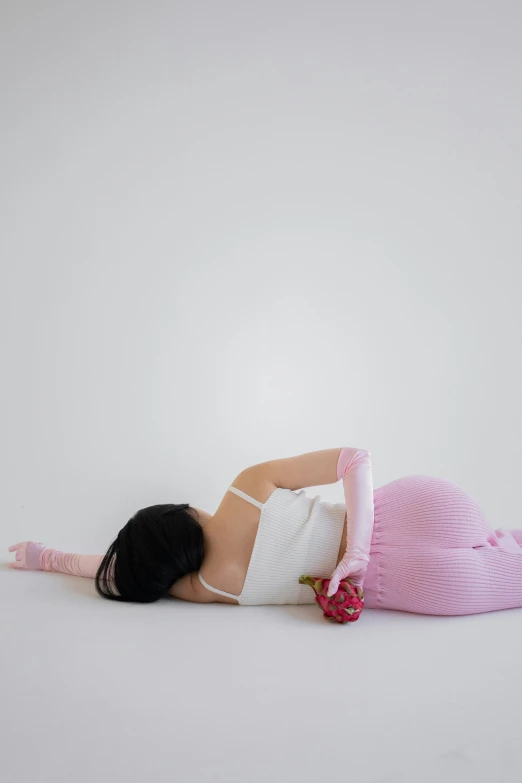 a woman laying on her stomach on the floor, inspired by Sarah Lucas, conceptual art, covered with pink marzipan, leotard and leg warmers, lu ji, with a white background