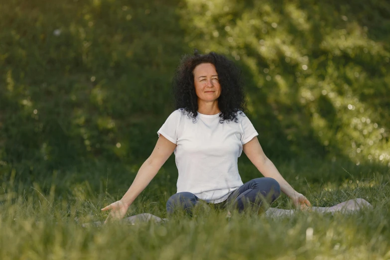 a woman sitting in the grass doing yoga, a portrait, by Attila Meszlenyi, unsplash, avatar image, neri oxman, low quality photo, at a clearing