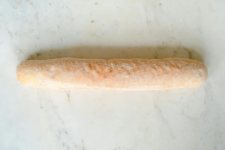 a long loaf of bread sitting on top of a counter, carrara marble, natural soft rim light, small finely stippled light, portrait n - 9