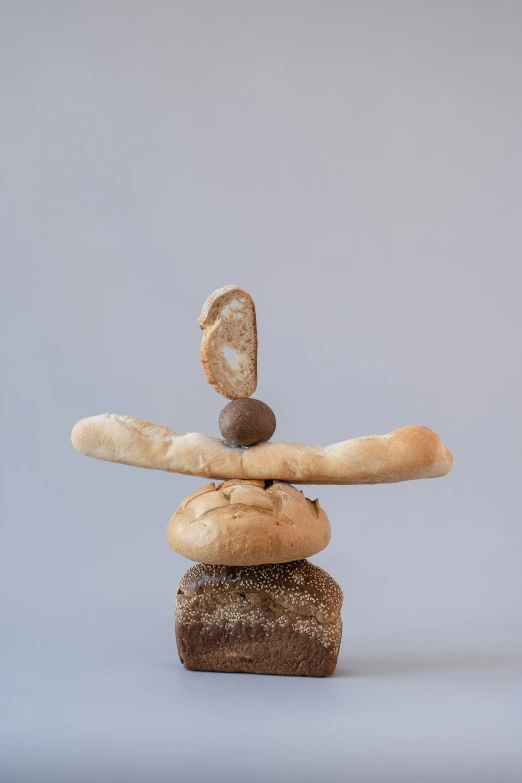 a stack of bread sitting on top of each other, a surrealist sculpture, inspired by Jan Kupecký, balance, nut, brown:-2, made of food