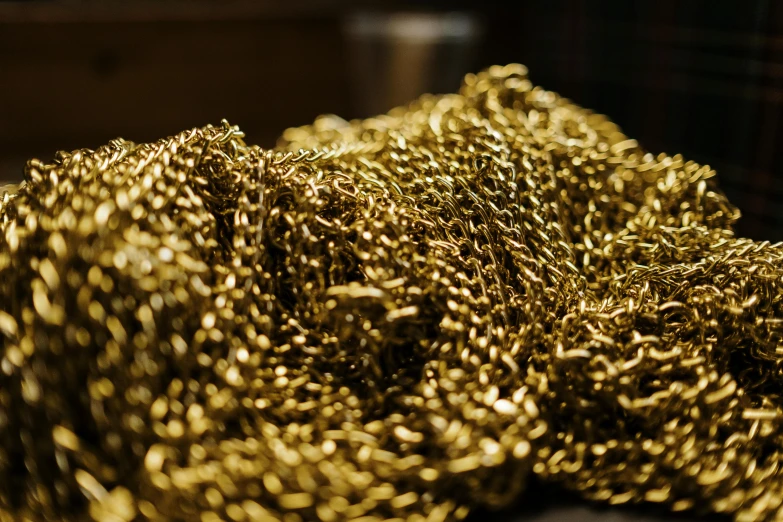 a pile of gold chain sitting on top of a table, by Julia Pishtar, unsplash, fan favorite, chain mail, gold trimmings, instagram post