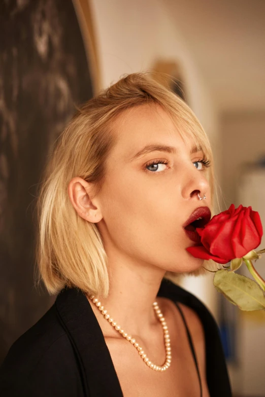 a woman with a rose in her mouth, an album cover, inspired by Hedi Xandt, trending on unsplash, sydney sweeney, in style of terry richardson, androgynous male, hollywood promotional image