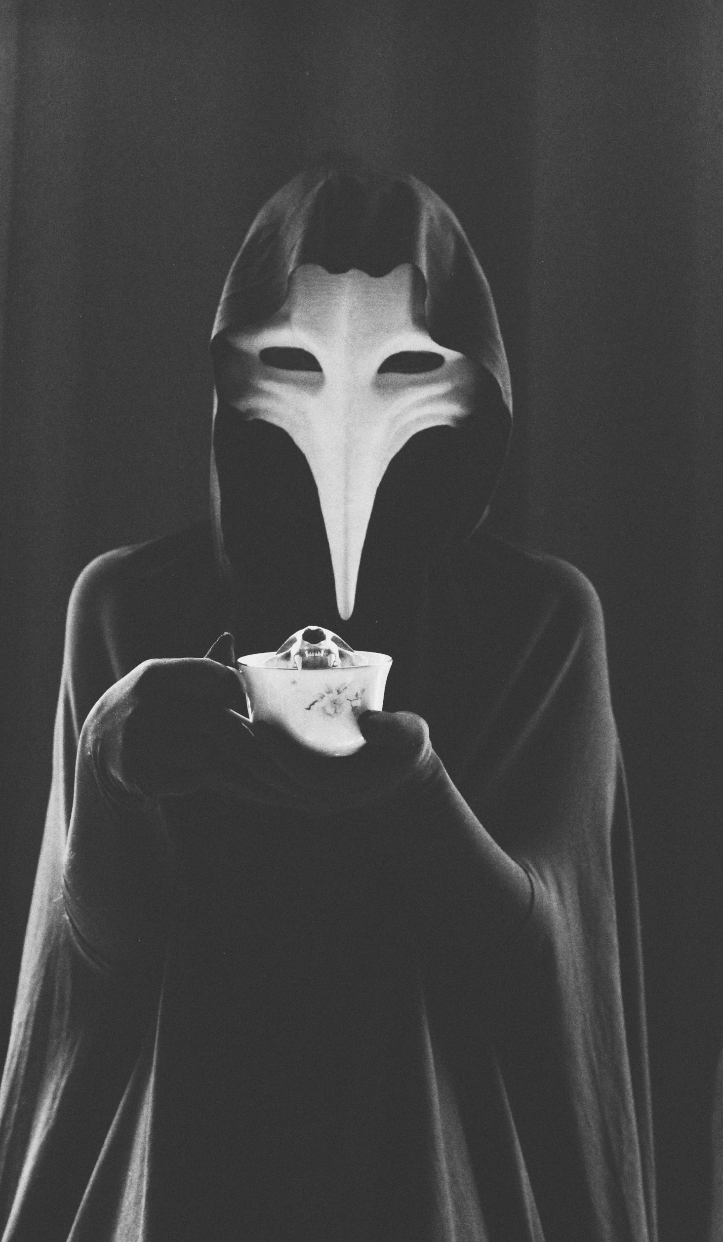 a black and white photo of a person holding a cup, inspired by Pietro Longhi, aestheticism, plague mask, /!\ the sorceress, adim kashin, morning coffee