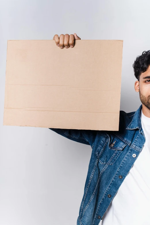 a man holding a cardboard board over his head, pexels contest winner, renaissance, lean man with light tan skin, a portrait of rahul kohli, slightly pixelated, non binary model