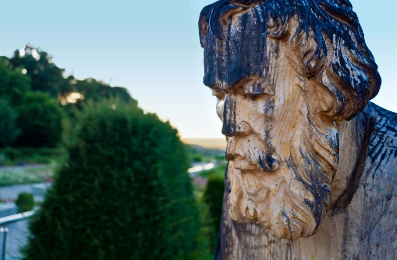 a wooden statue of a man with a beard, a marble sculpture, by Julian Allen, unsplash, mannerism, landscape vista, peering over from his heavy, carved from sapphire stone, from italica