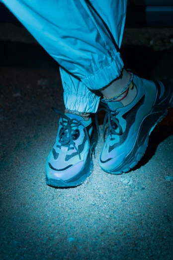 a close up of a person's shoes in the dark, an album cover, by Elsa Bleda, graffiti, blue sand, rapper, blue gray, wearing urban techwear