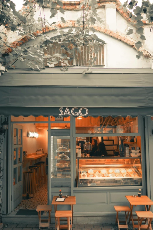 a store front with tables and chairs in front of it, a picture, by Cagnaccio di San Pietro, sage green, hygge, brown bread with sliced salo, thumbnail