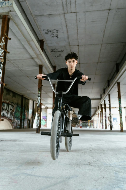 a man flying through the air while riding a bike, an album cover, pexels contest winner, realism, confident pose, junji ito style, black, bulky build