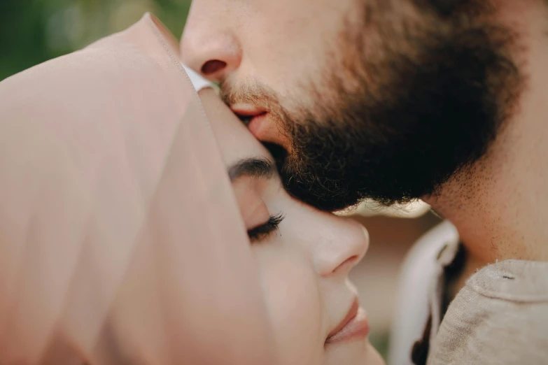 a close up of a person kissing a woman, a picture, trending on pexels, hurufiyya, arab man light beard, face covered, high forehead, clean face and body skin