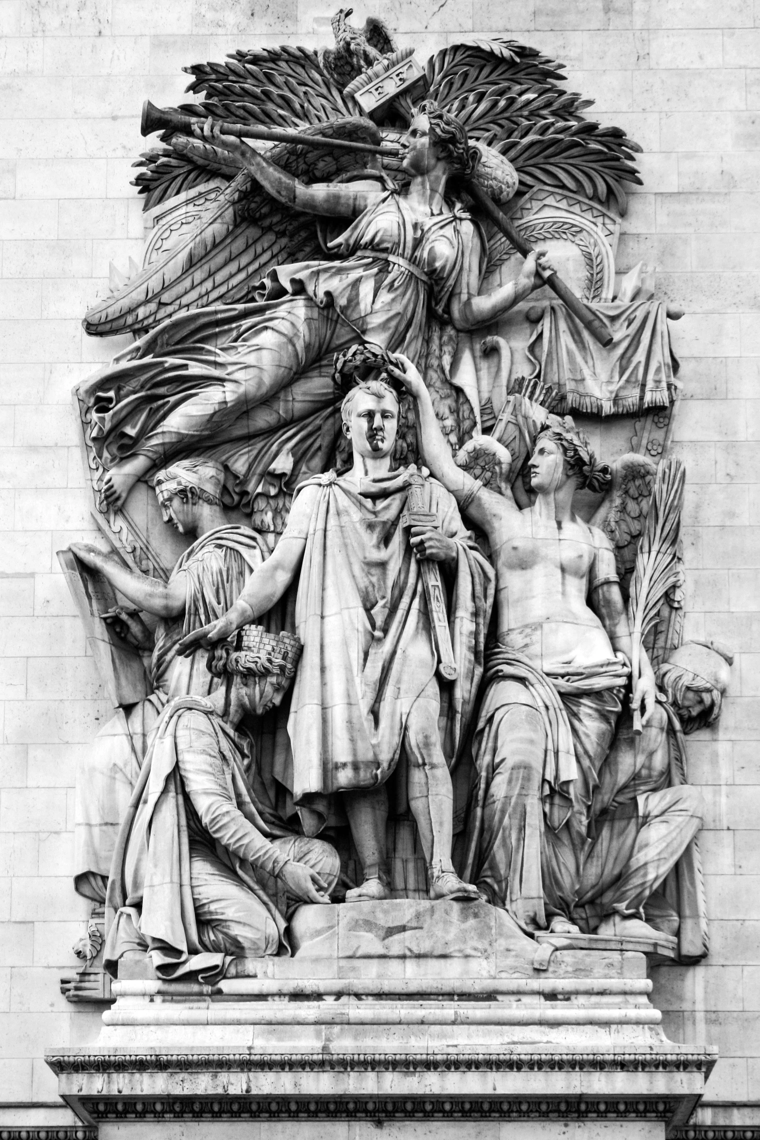 a black and white photo of a statue on the side of a building, by Luca della Robbia, neoclassicism, arc de triomphe full of graffiti, arms held high in triumph, prussia, triad of muses