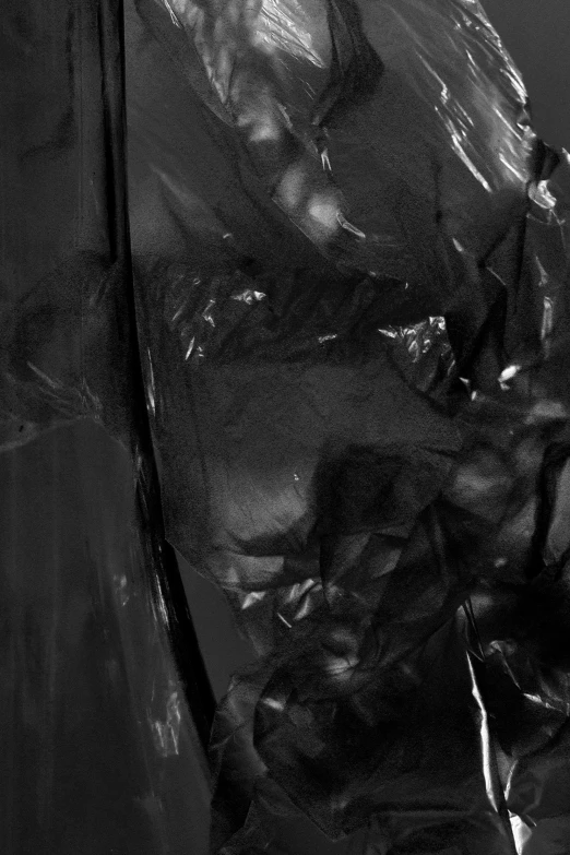 a black and white photo of a man in a raincoat, reddit, lyrical abstraction, plastic texture, black draconic - leather, detail, black fluid simulation