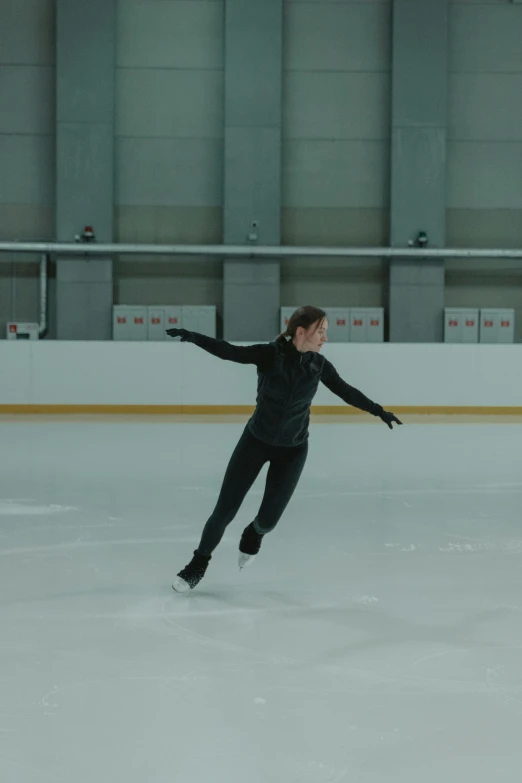 a man riding a skateboard on top of an ice rink, a hologram, inspired by Elizabeth Polunin, unsplash, arabesque, film still of emma watson, b - roll, wearing a tracksuit, f1.7