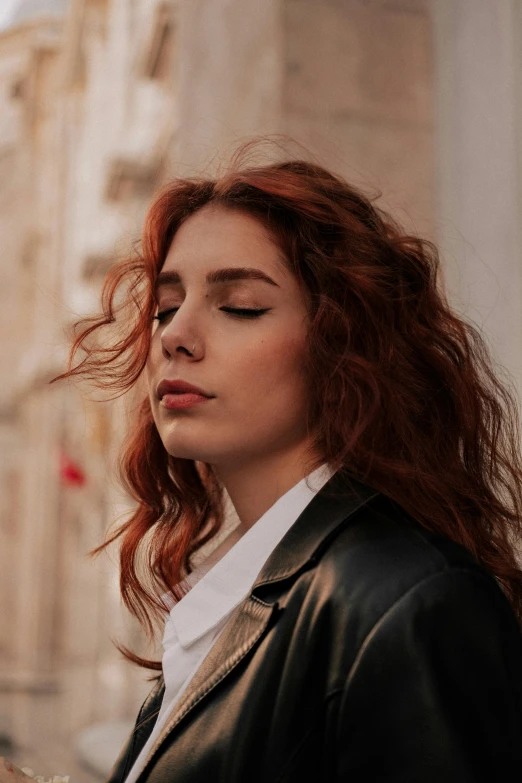 a woman with red hair standing in front of a building, inspired by Elsa Bleda, trending on pexels, renaissance, a man wearing a black jacket, beautiful jewish woman, young woman looking up, lorde