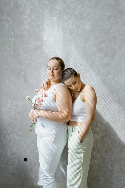 a couple of women standing next to each other, a picture, by Anna Füssli, trending on pexels, aestheticism, plus-sized, in white clothes, holding flowers, strong light