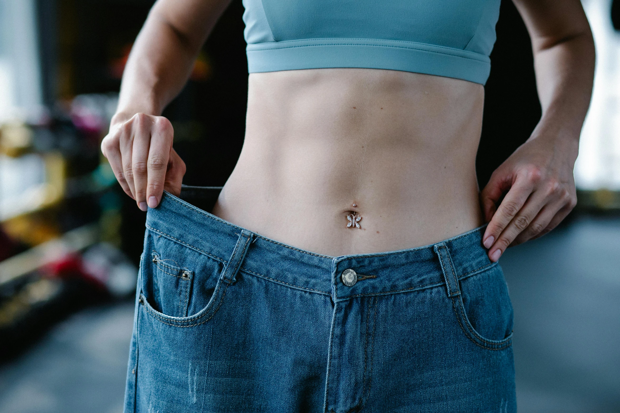 a close up of a person holding a pair of jeans, a tattoo, navel, wearing a tanktop and skirt, steroid use, full body image
