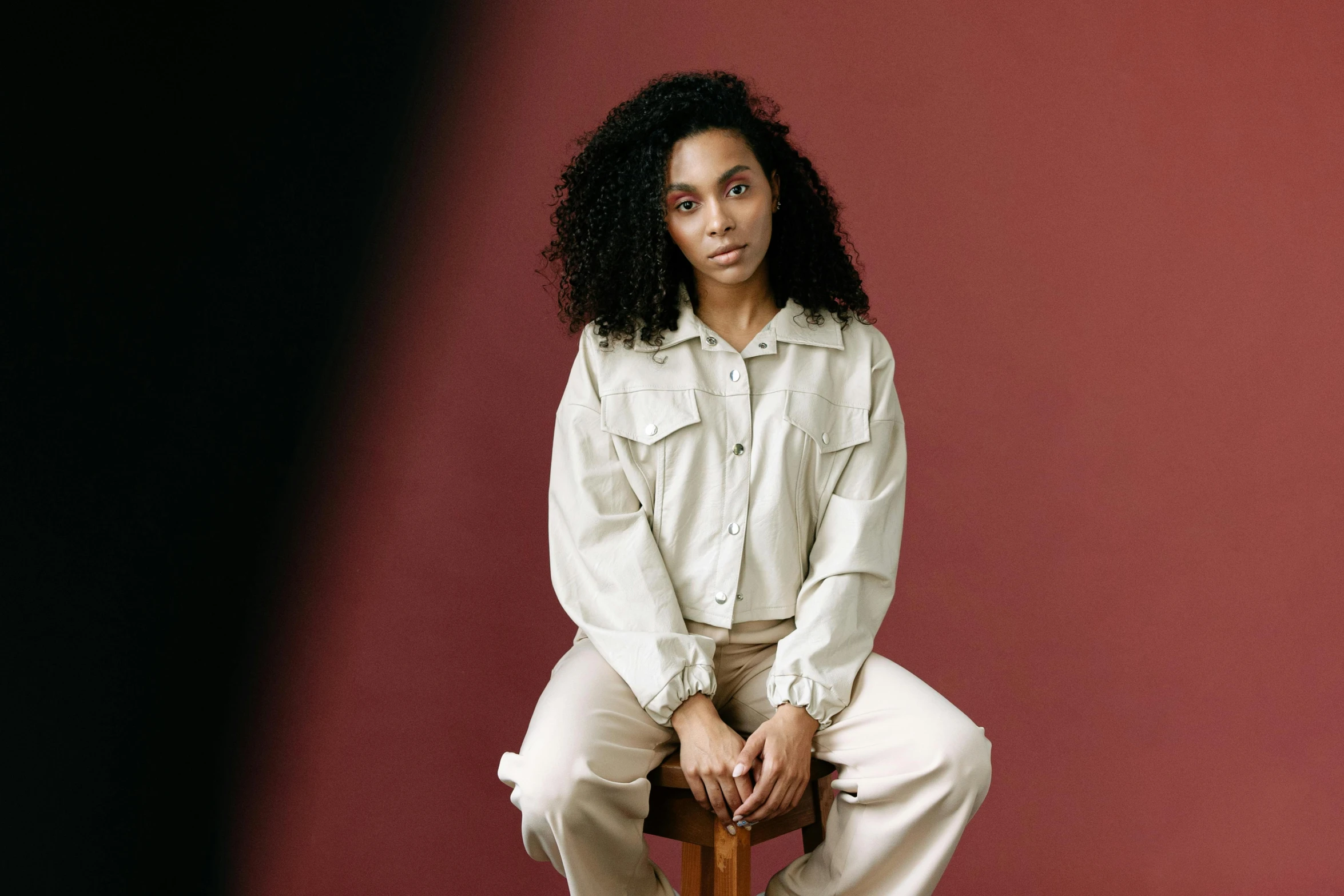 a woman sitting on top of a wooden chair, trending on pexels, renaissance, wearing a linen shirt, mixed-race woman, wearing a track suit, outfit photograph