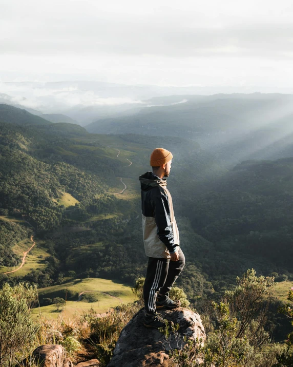 a person standing on top of a mountain, lush surroundings, profile image, strong sunlight, gray men