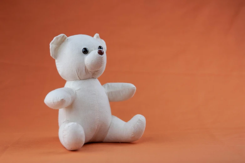 a white teddy bear sitting on an orange background, on a white table, ikenobo, medium, thumbnail