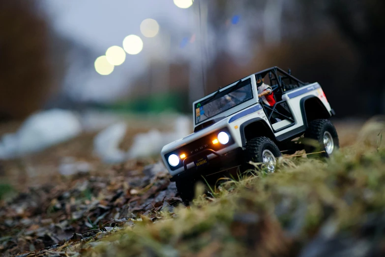 a toy jeep that is sitting in the grass, a tilt shift photo, by Sven Erixson, unsplash, photorealism, leds, led, mini, off - road