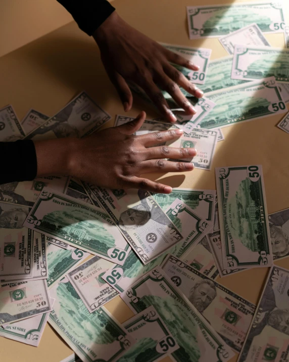 a bunch of money sitting on top of a table, an album cover, by Jessie Alexandra Dick, trending on unsplash, process art, hands of men, lgbtq, politics, puzzling