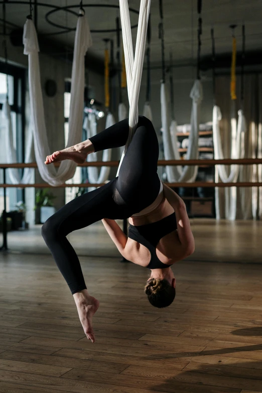 a woman hanging upside down on a hammock, arabesque, ouchh and and innate studio, highly upvoted, square, local gym