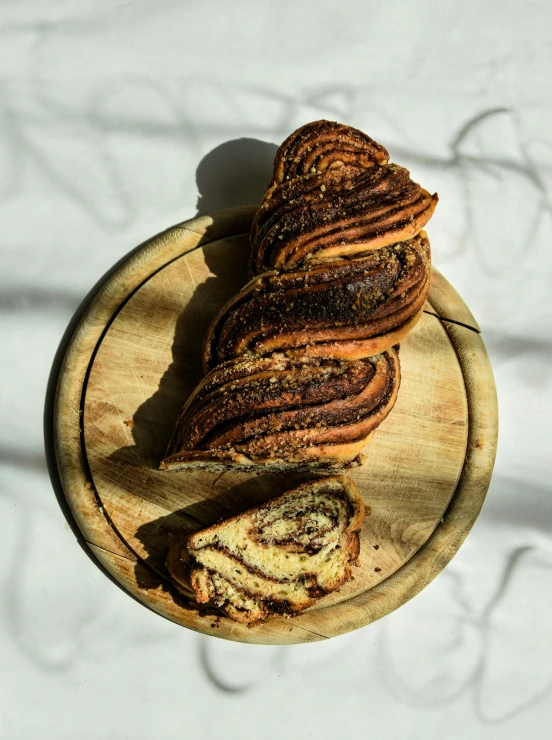 a wooden plate topped with slices of bread, organic swirling igneous rock, twisted braid, gucci bread, panorama