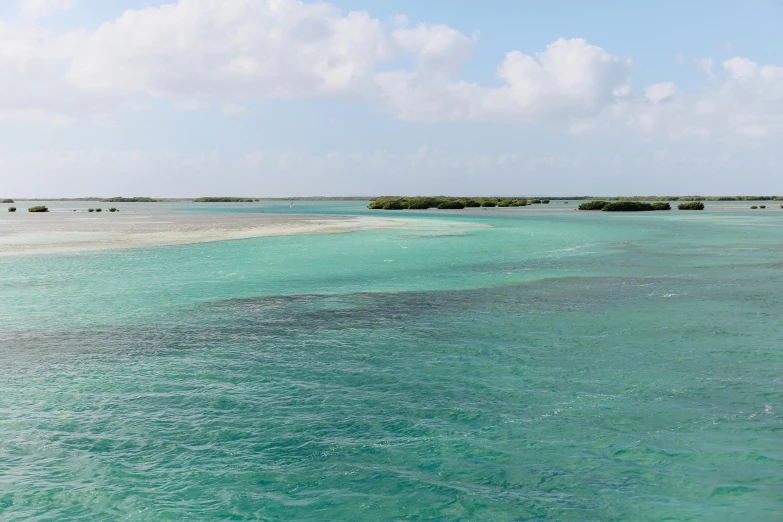 a body of water with small islands in the distance, by Charlotte Harding, pexels contest winner, hurufiyya, aruba, green water, somalia, 3 / 4 wide shot