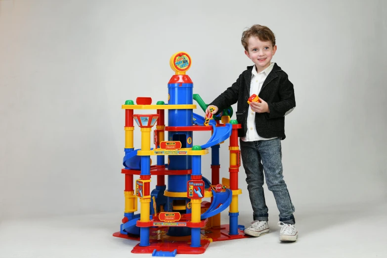 a young boy standing next to a toy tower, inspired by Rube Goldberg, instagram, bauhaus, full product shot, multi colour, superhero, toddler