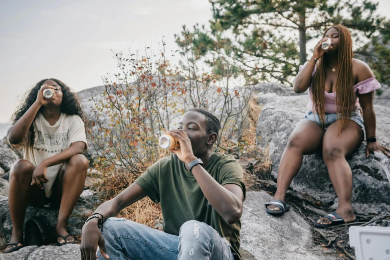 a group of people sitting on top of a rock, trending on pexels, drinking and smoking, african canadian, profile image, childish