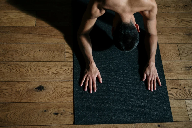 a man doing a yoga pose on a yoga mat, by Carey Morris, pexels contest winner, figuration libre, half body cropping, top down, panels, indoor picture