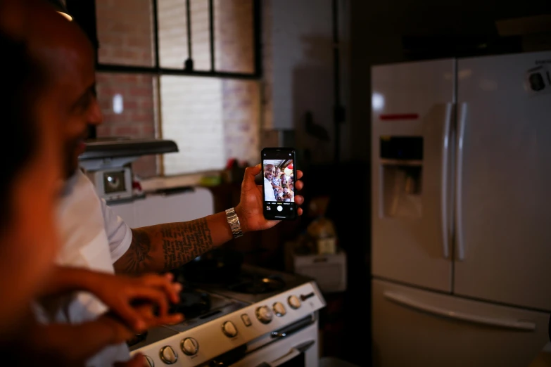 a man taking a picture of himself in the kitchen, nipsey hussle, phot