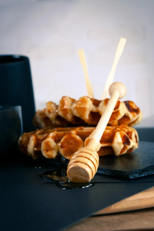 a stack of waffles sitting on top of a table, inspired by Joris van der Haagen, hurufiyya, wooden staff, slate, bee, product display photograph