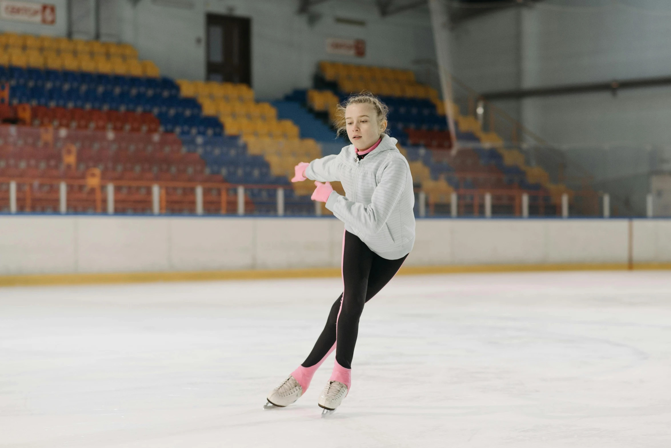 a woman is skating on an ice rink, a portrait, pexels contest winner, arabesque, sydney sweeney, wearing a tracksuit, 1 6 years old, juno promotional image