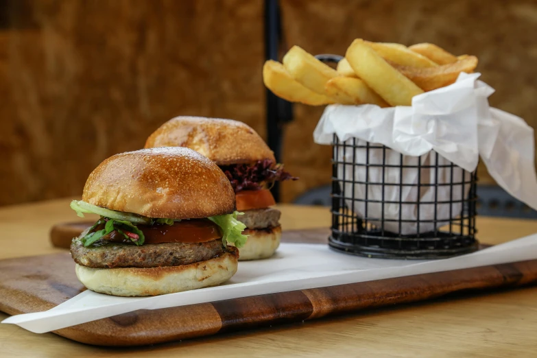 a couple of burgers sitting on top of a wooden cutting board, by Tom Bonson, unsplash, with fries, caulfield, 🦩🪐🐞👩🏻🦳, restaurant menu photo