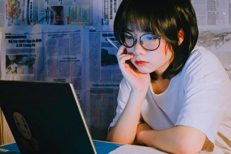 a woman sitting in front of a laptop computer, a picture, by Jang Seung-eop, trending on pexels, realism, blue rimmed glasses, late night melancholic photo, of a youthful japanese girl, scientific study