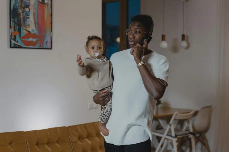 a man talking on a cell phone while holding a baby, wakanda, busy room, ready to model, busy night