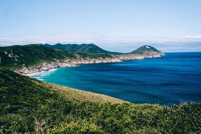 a large body of water next to a lush green hillside, pexels contest winner, mingei, cape, avatar image, seaside, 90s photo