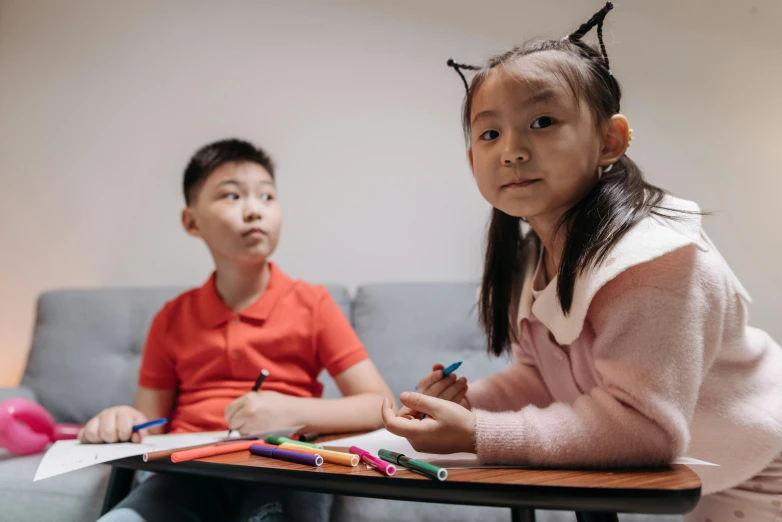 a couple of kids sitting on top of a couch, a child's drawing, by Jang Seung-eop, pexels contest winner, seated at a table, sitting in the classroom, looking serious, 15081959 21121991 01012000 4k