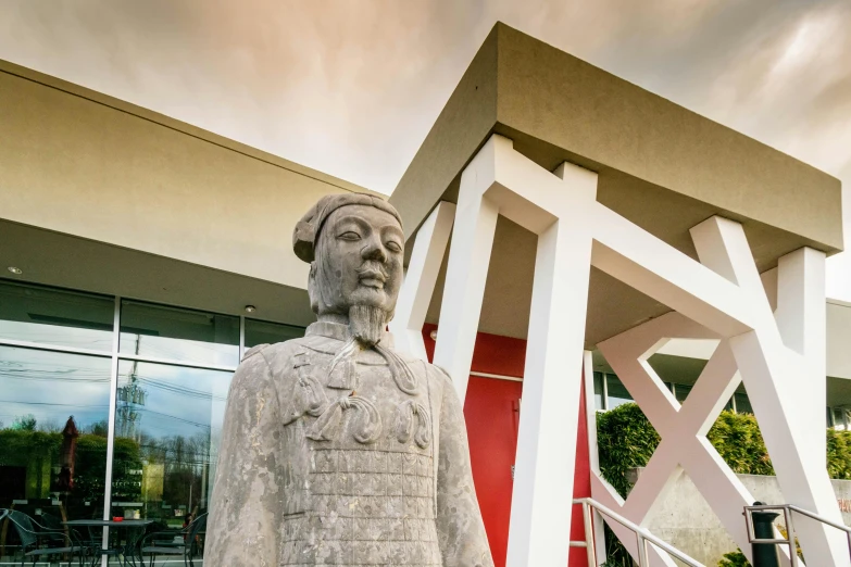 a statue of a man standing in front of a building, a statue, inspired by Guo Xi, academic art, vietnam, vaughan ling, museum photograph, face forward