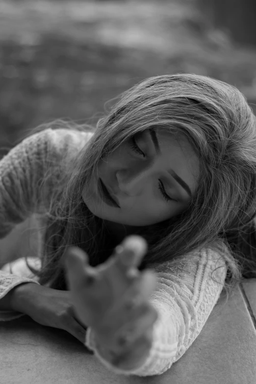 a woman laying on top of a cardboard box, a black and white photo, by Niyazi Selimoglu, tumblr, hurufiyya, natalia dyer, crying and reaching with her arm, still from a music video, windy hair