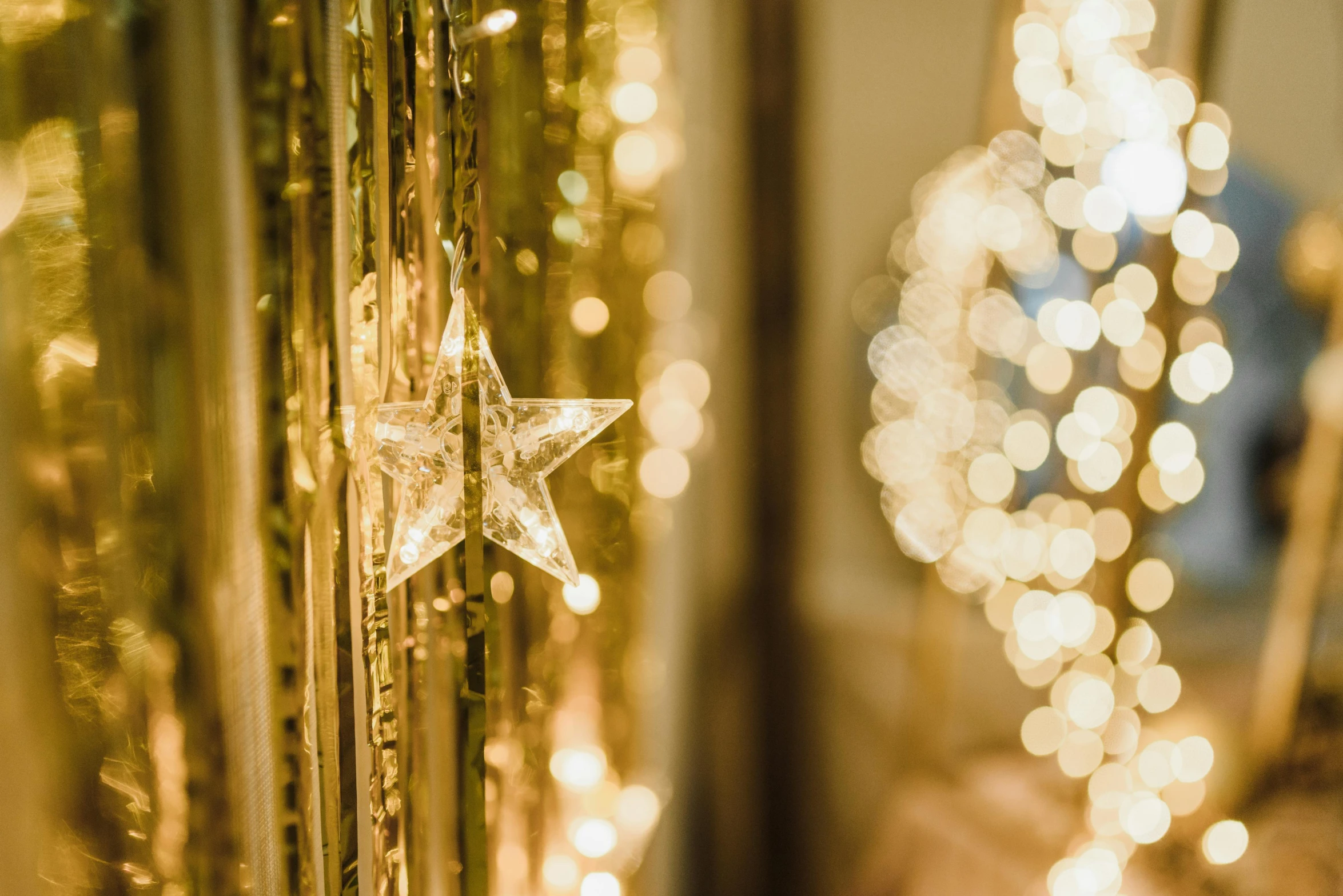 a close up of a christmas tree with lights in the background, by Julia Pishtar, pexels contest winner, light and space, background of a golden ballroom, star inside, beaded curtains, relaxed. gold background