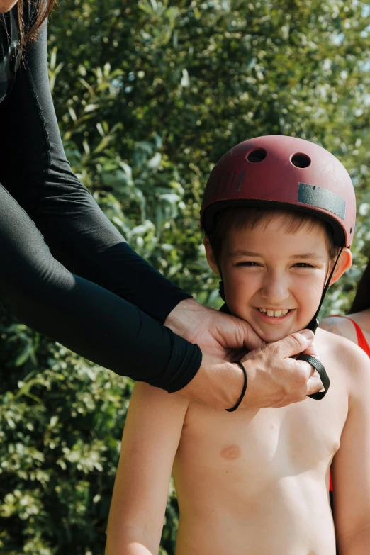 a woman helping a young boy on a skateboard, pexels contest winner, holding helmet, closeup of arms, happy face, view from above