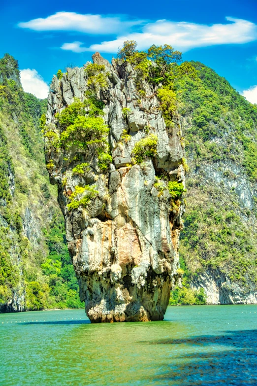 a large rock in the middle of a body of water, thailand, tall spires, space ship above an island, fjords