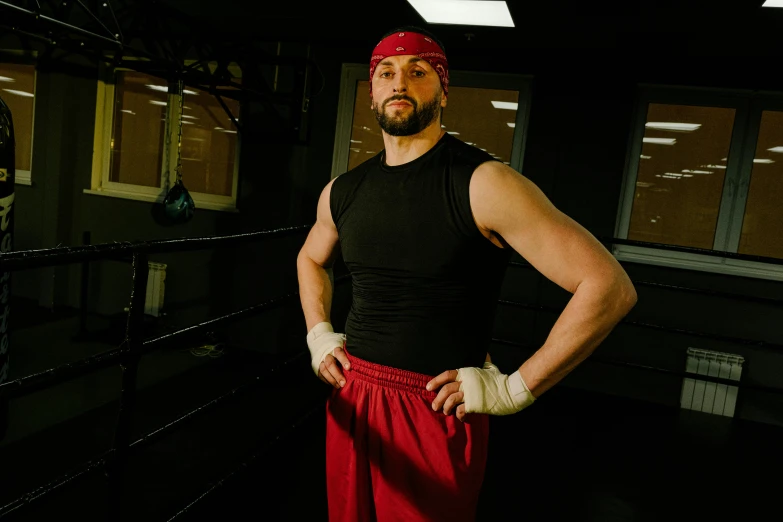 a man standing in a boxing ring with his hands on his hips, a portrait, inspired by Volkan Baga, featured on reddit, wearing a red backwards cap, rugged man portrait, marketing photo, wearing fitness gear