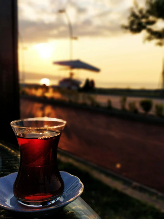 a cup of tea sitting on top of a table, by Ismail Acar, pexels contest winner, hurufiyya, ((sunset)), mixture turkish and russian, drinks, 15081959 21121991 01012000 4k