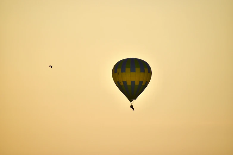 a hot air balloon is flying in the sky, a picture, pexels contest winner, figuration libre, pale yellow sky, silhouette!!!, taken in the early 2020s, photo 8 k