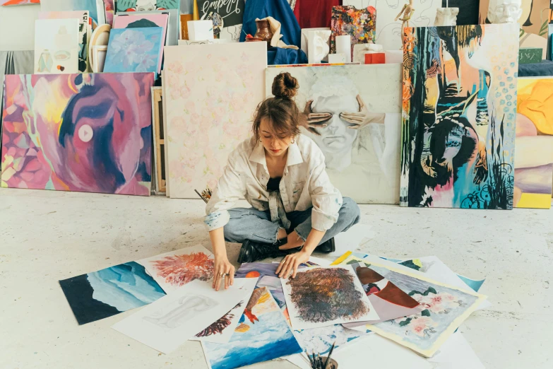 a woman sitting on the floor surrounded by paintings, trending on pexels, process art, artist wearing overalls, art stations, profile image, acrylic paint pour