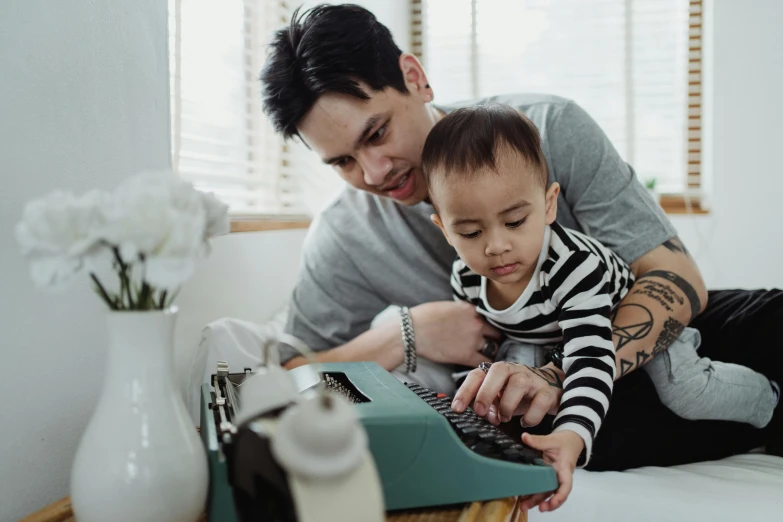 a man holding a baby and typing on a typewriter, a screenshot, pexels contest winner, darren quach, lachlan bailey, father with child, avatar image