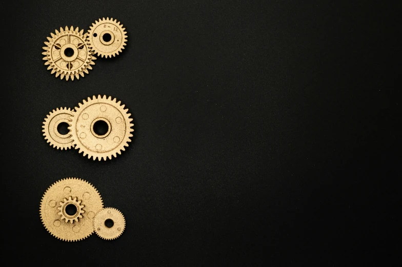 a number of gears on a black surface, an album cover, unsplash, gold and black, programming, but minimalist, maintenance photo