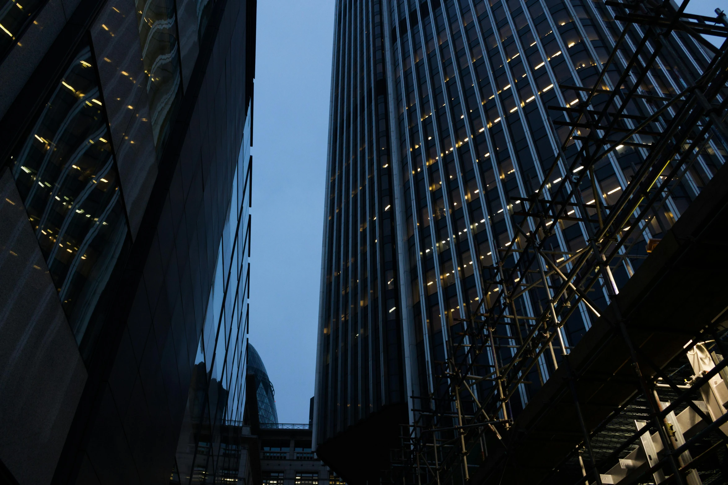 a couple of tall buildings next to each other, inspired by Richard Wilson, unsplash, it's getting dark, tall obsidian architecture, seen from outside, thumbnail